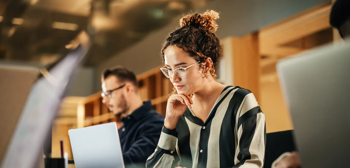 Une femme lisant sur un laptop.