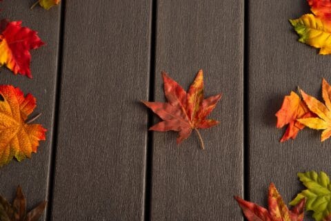 Feuilles d'automne sur une terrasse en bois composite