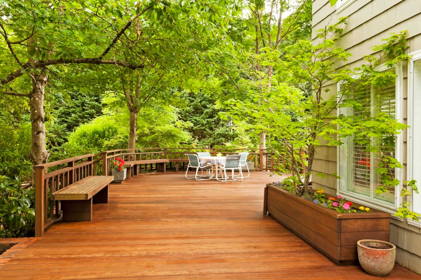 Une magnifique terrasse arrière entourée d'arbres verts
